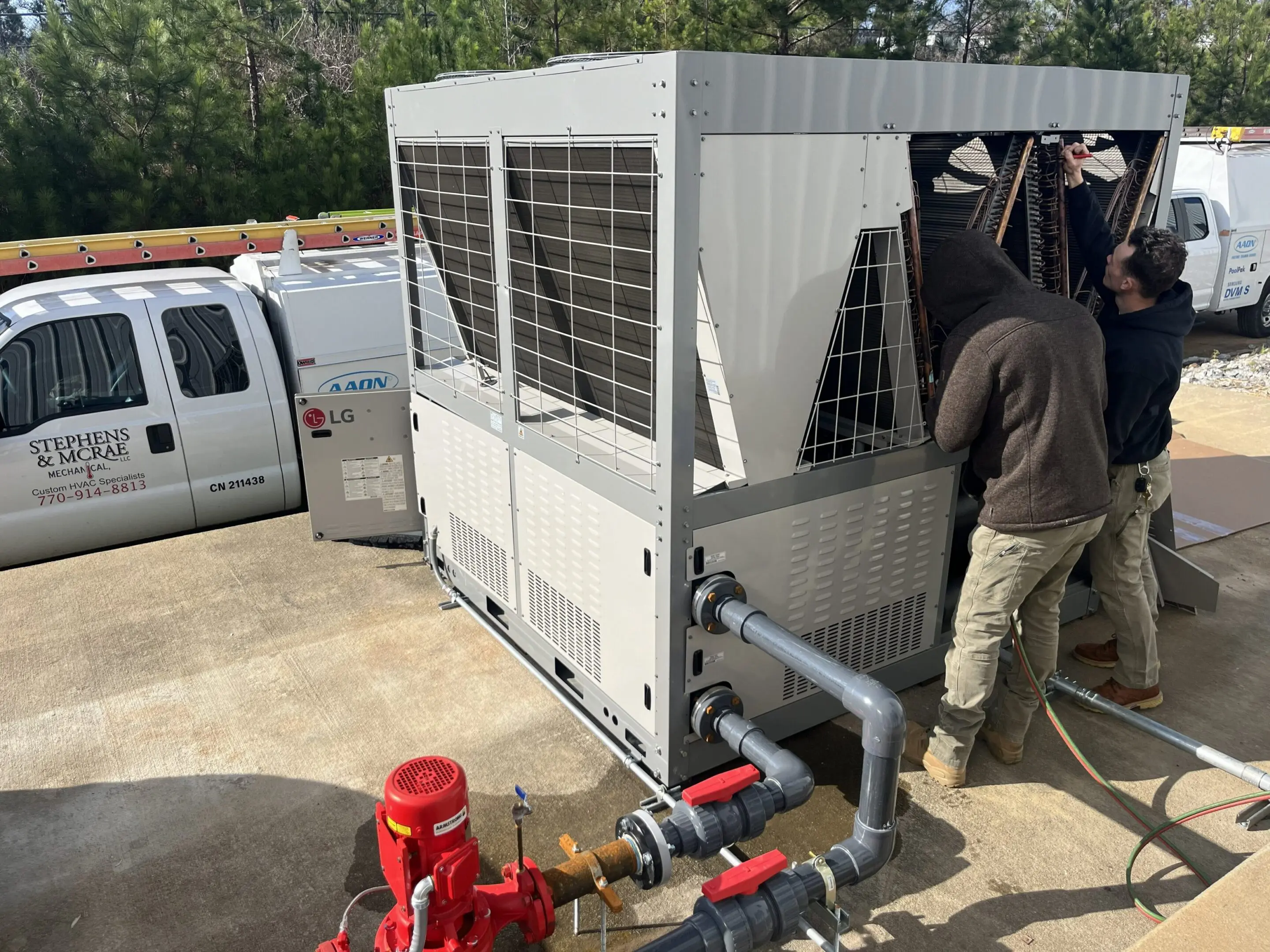 Technicians servicing rooftop HVAC unit