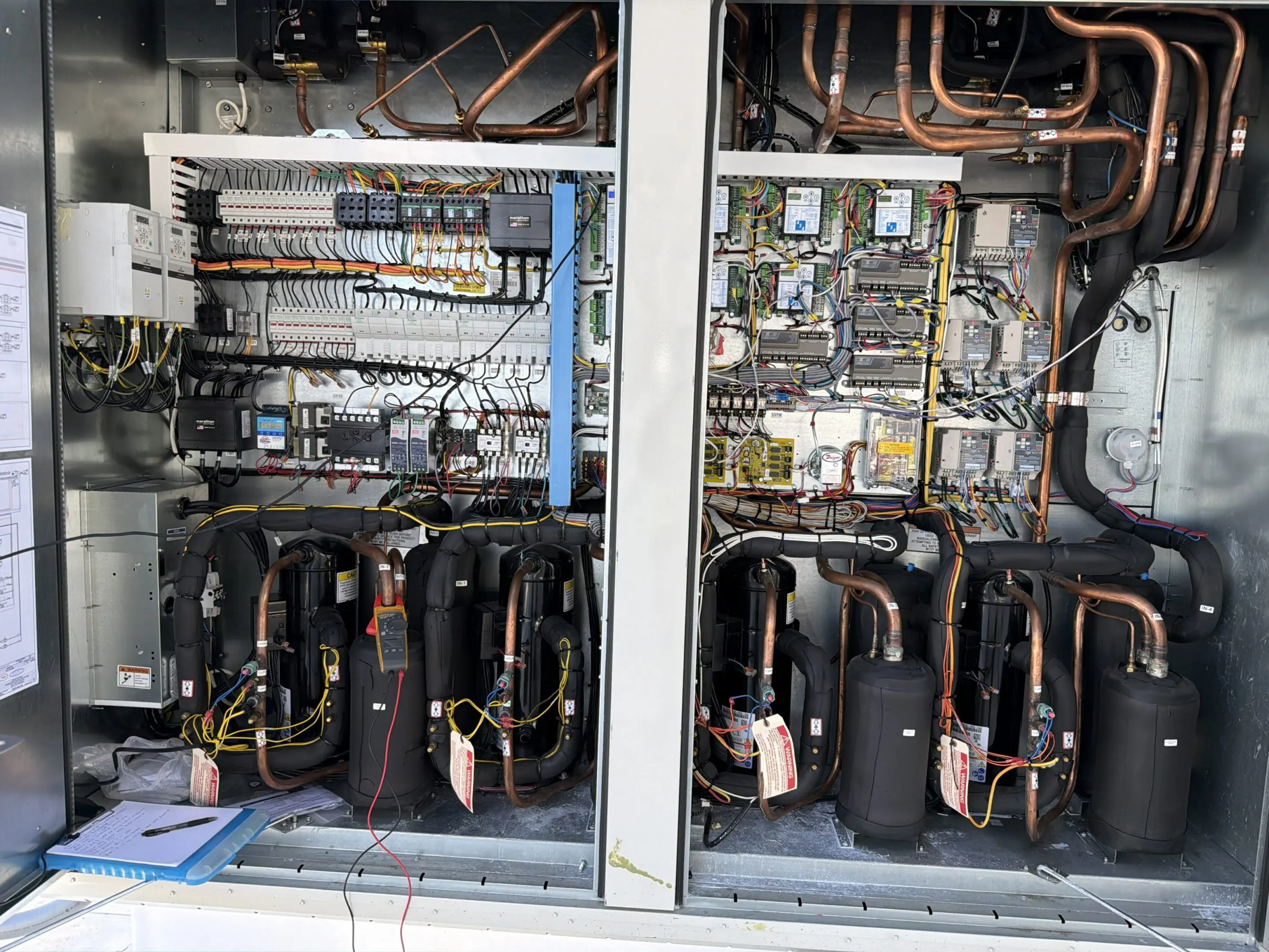 Open HVAC cabinet with compressors and wiring